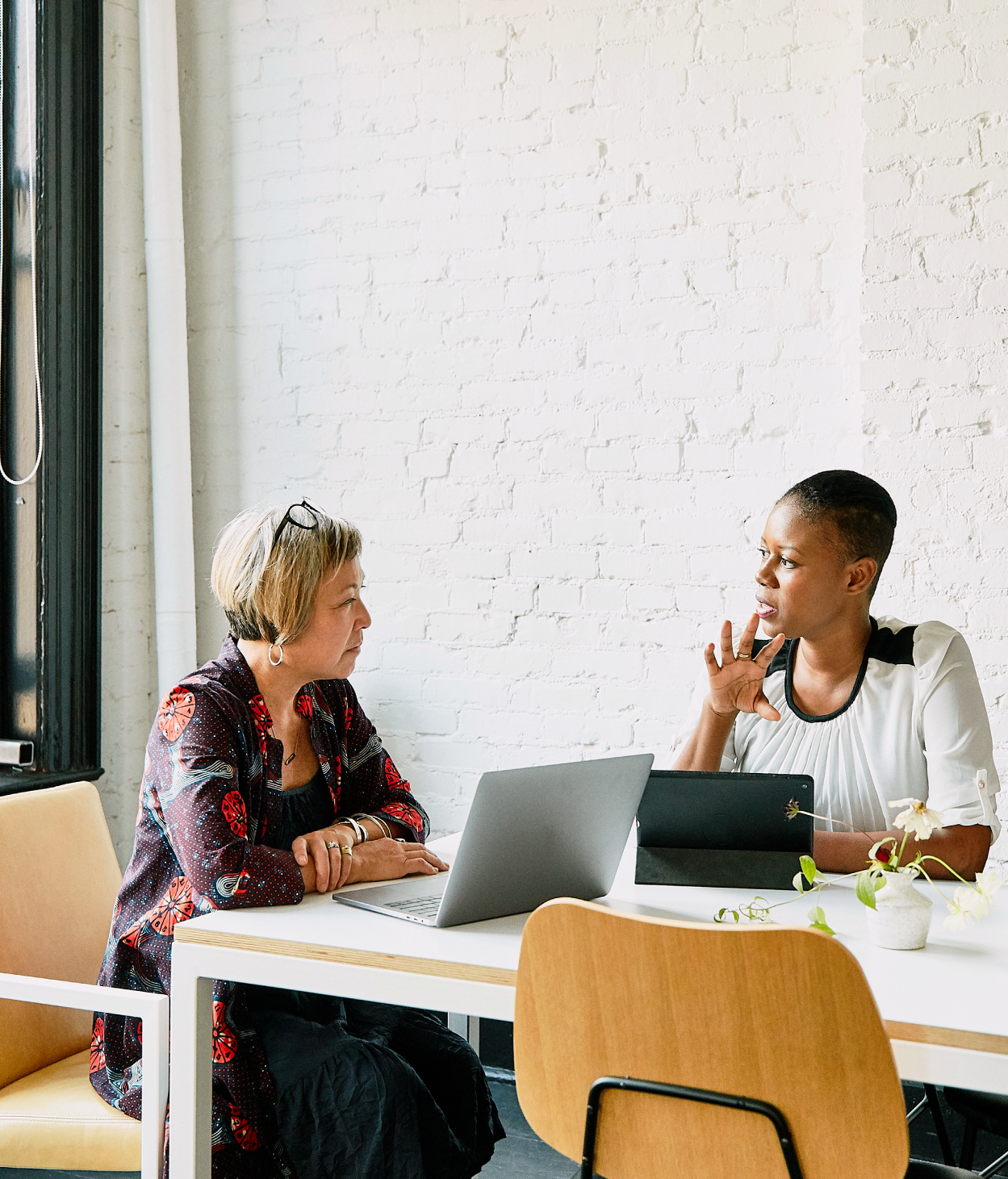Two businesswomen hold a meeting in a conference room.